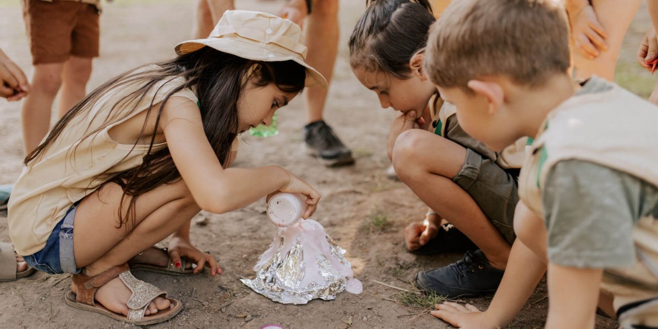 Kinder sind als Entdecker verkleidet und führen ein Vulkan-Experiment durch.